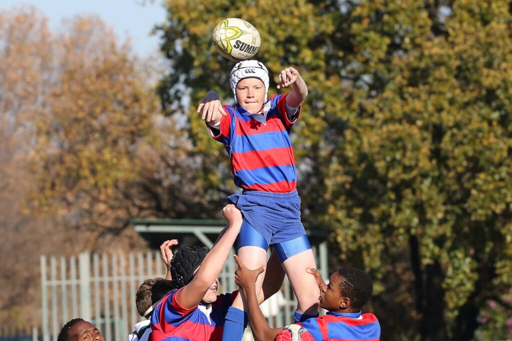 Crafting Captivating Headlines: Your awesome post title goes here Young rugby players in a fierce game moment outdoors, capturing teamwork and sport intensity.