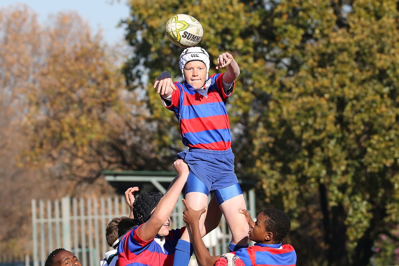 Young rugby players in a fierce game moment outdoors, capturing teamwork and sport intensity.
